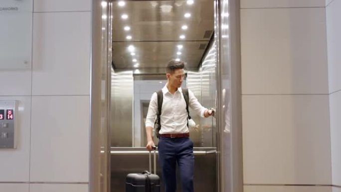 旅行、酒店电梯和带行李箱的人在日本大堂出差。酒店、公司旅客和商人，带行李按钮，用于建筑升降机门关闭的