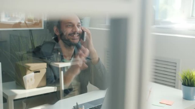 中东上班族在现代玻璃墙办公室里用手机聊天微笑