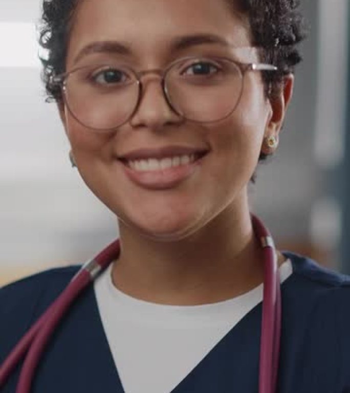 垂直屏幕。医院病房: 摆姿势美丽的黑人女护士长，医生，外科医生迷人地微笑着，亲切地看着镜头。设备先进