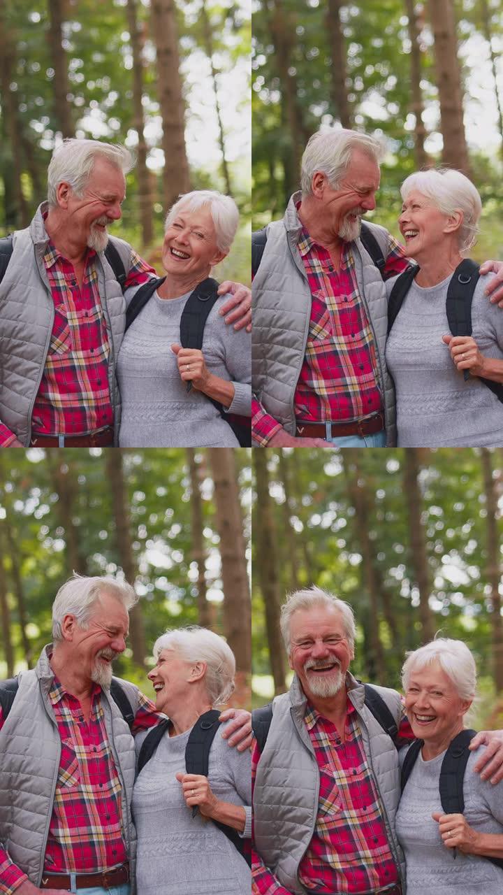 微笑活跃的老年夫妇一起徒步穿越林地乡村的垂直视频肖像-慢动作拍摄