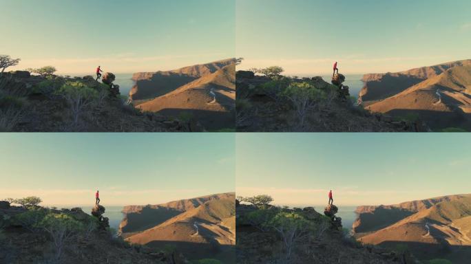西班牙加那利群岛戈梅拉景观中的SLO MO WS男子跳上岩石