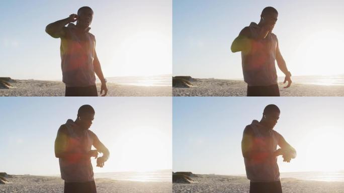 非裔美国人检查智能手表，在海边户外锻炼