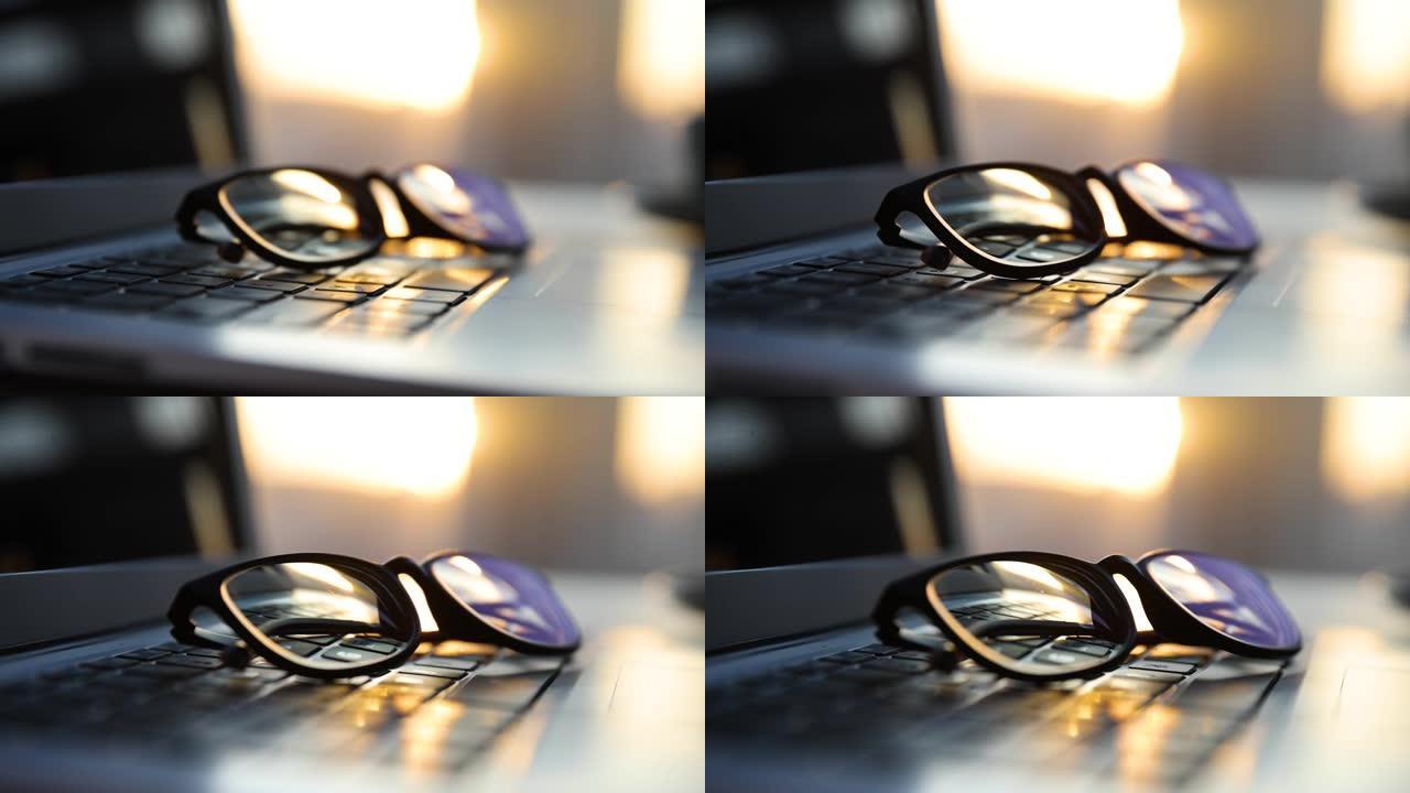 带阳光的笔记本电脑上的眼镜