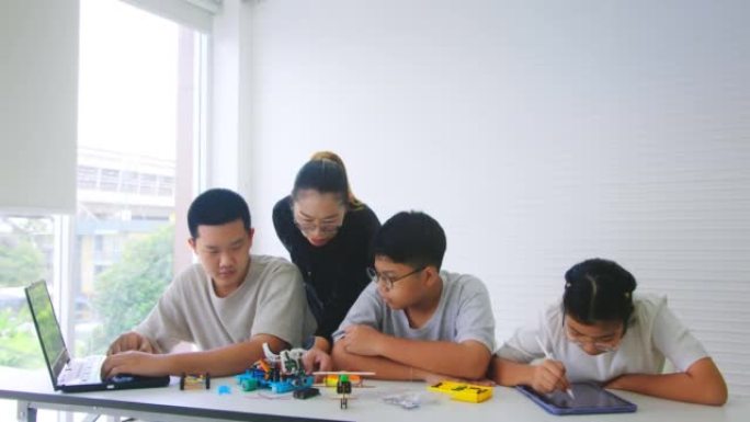 老师的教学和建议为孩子们使用编码机器人进行编程，可以改善学校的逻辑思维。小学教育STEM教育概念。