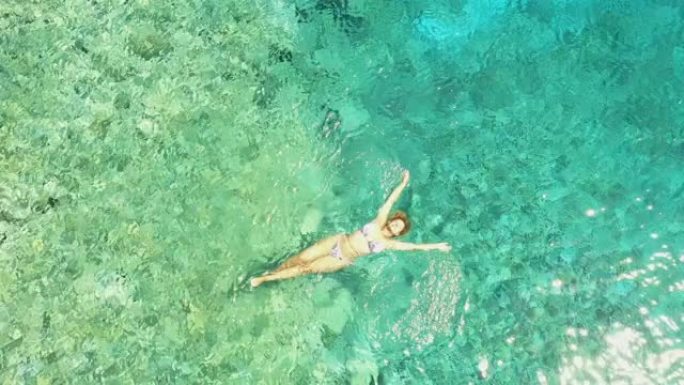 漂浮在亚得里亚海绿松石水上的空中女人