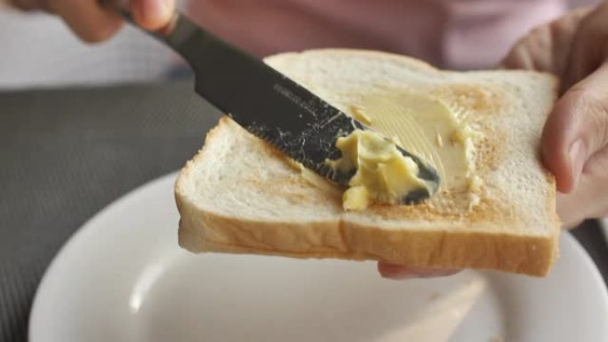 将人造黄油撒在面包上的特写镜头