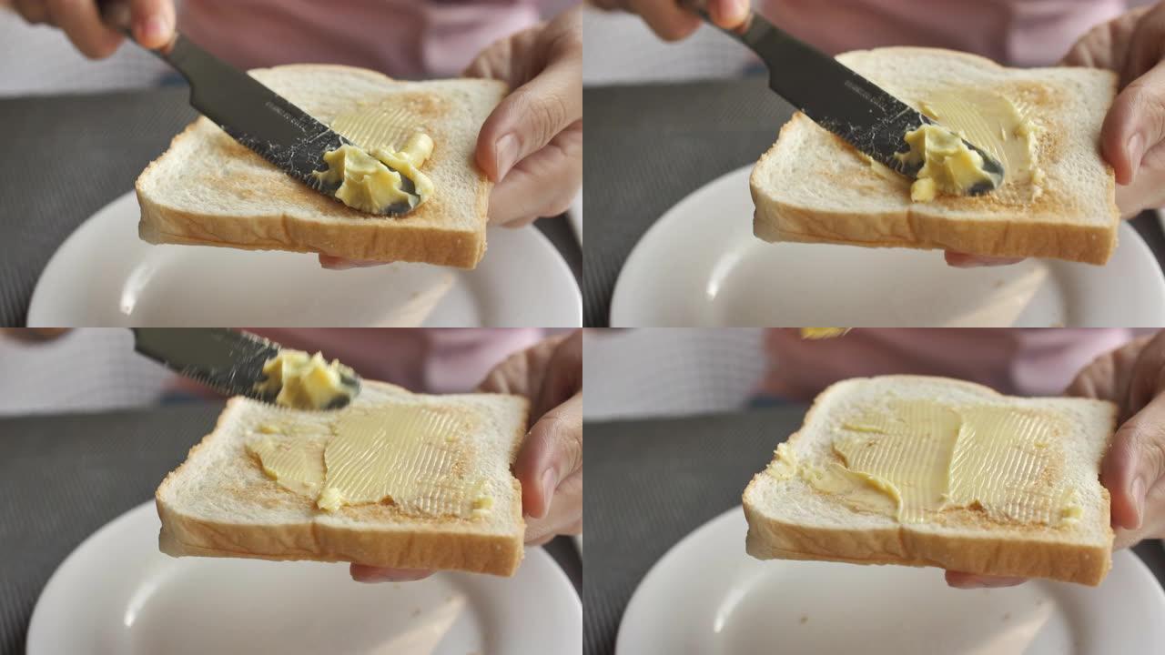 将人造黄油撒在面包上的特写镜头