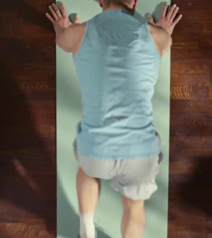垂直屏幕顶视图运动: 漂亮的家伙在家里的垫子上做登山运动。肌肉发达，健康，非常英俊的运动员在他的公寓
