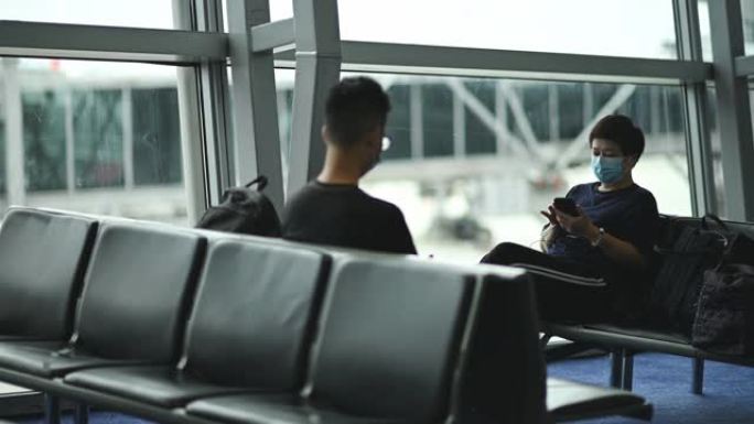 亚洲中国游客在机场用口罩观察社交距离