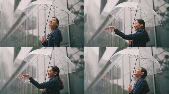 亚洲女商人在雨中撑伞时感觉良好