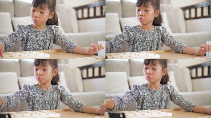 小女孩在家里的客厅玩耍和学习字母