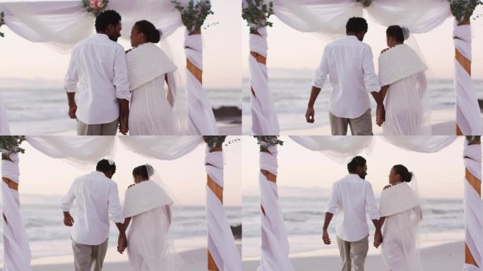 恋爱中的非裔美国夫妇结婚，牵手并在沙滩上散步