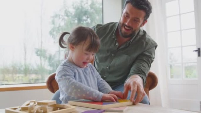 父亲与唐氏综合症女儿一起在家玩木制游戏