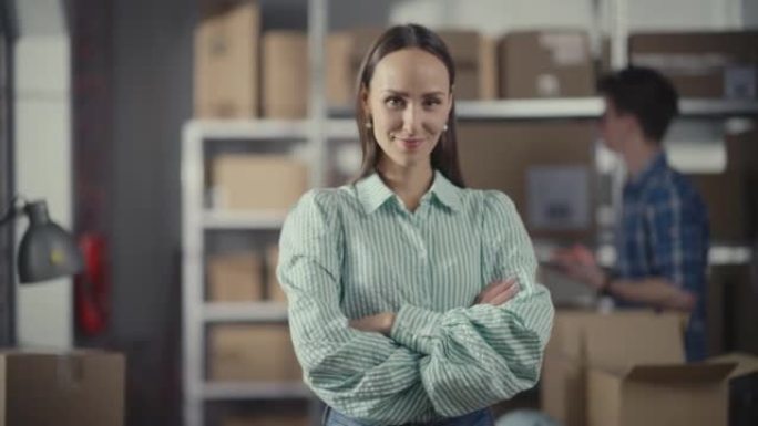 一个成功的小企业主微笑着，双臂交叉，看着相机的肖像。在网上商店仓库工作时赋予迷人的高加索女性权力。
