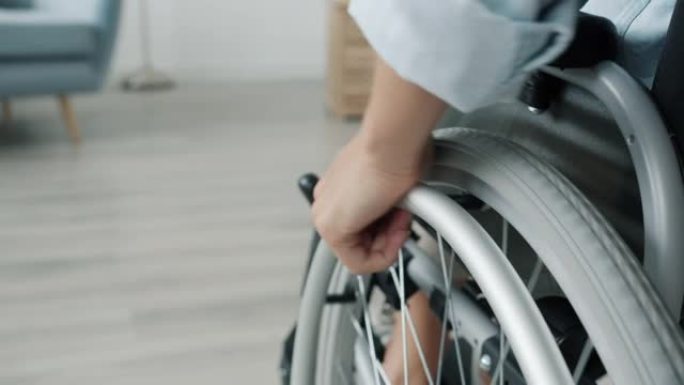 女人手在家室内移动轮椅的特写慢动作
