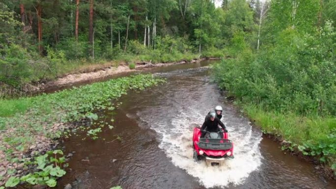 驾驶ATV穿越河流的人的空中镜头