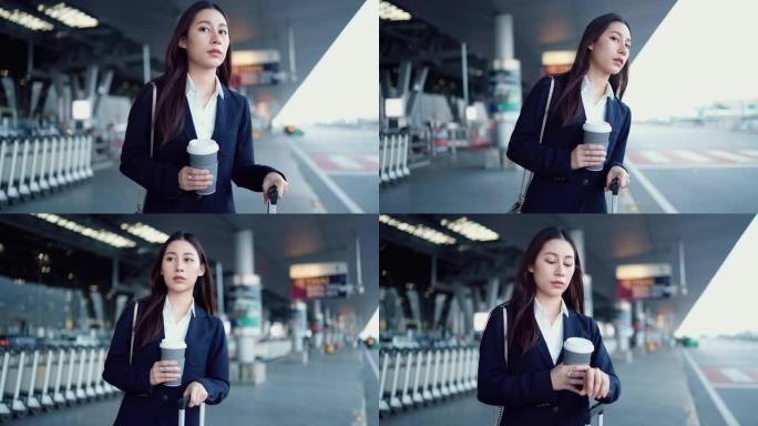 投资者妇女在机场出发区手持咖啡杯等候机场接驳巴士