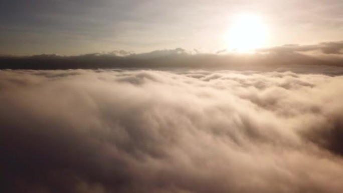 空中拍摄到云层和天空上方的空中，日出在山上