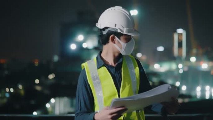 建筑师持有计划并检查夜班的建筑进度。