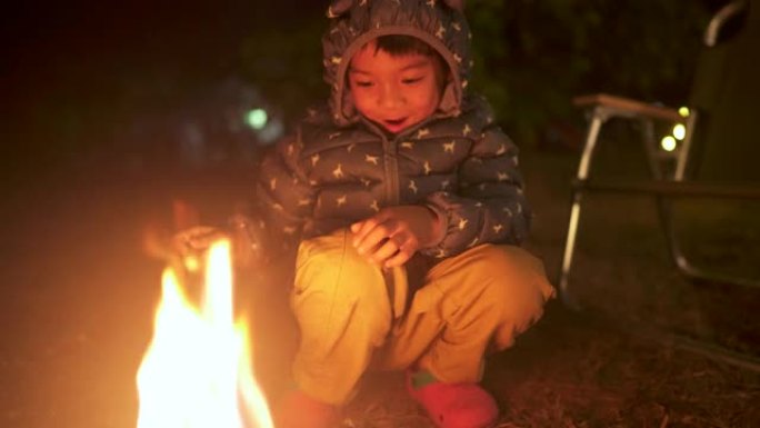 亚洲小男孩在露营时享受篝火