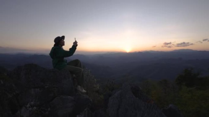 女人在山顶上徒步旅行，举手庆祝成功