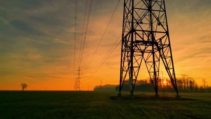 日落时田园诗般的乡村的电塔和电线