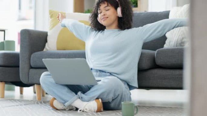 快乐，微笑和无忧无虑的女人在笔记本电脑上在线浏览并伸展运动，戴着耳机并在家中听音乐。内容黑人女性在周