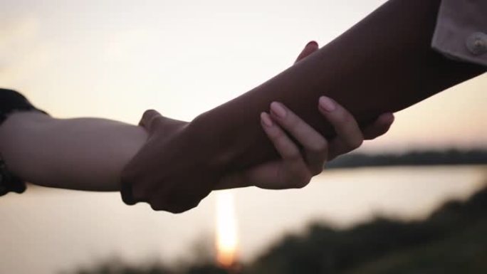 SLO MO白人妇女的手和黑人妇女的手互相握住