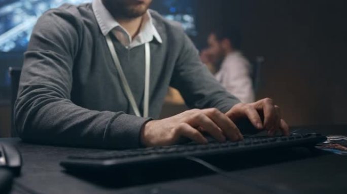 一个穿着毛衣的男人在电脑上工作