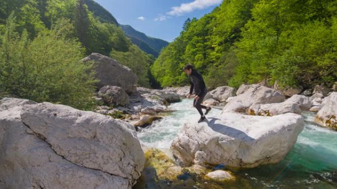 年轻人在雄伟的风景中跳过山河