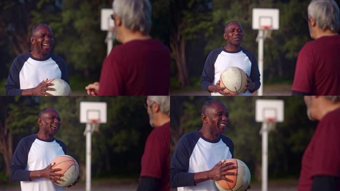 资深非裔美国人与朋友在户外拿着篮球大笑