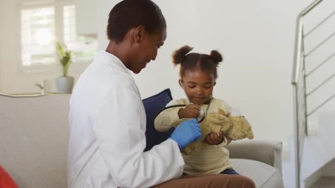 非裔美国女孩在医疗家庭访问期间使用听诊器并微笑