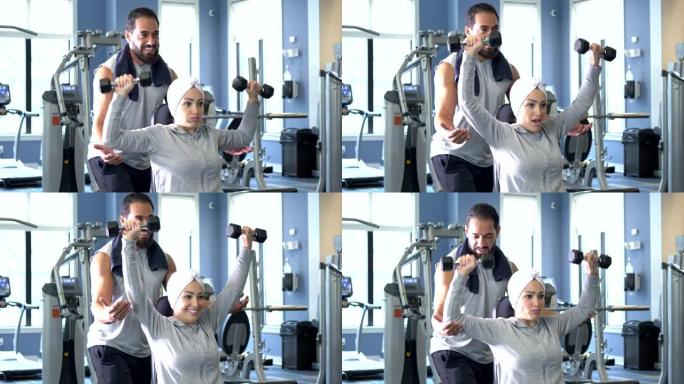 中东夫妇在健身房锻炼，练哑铃