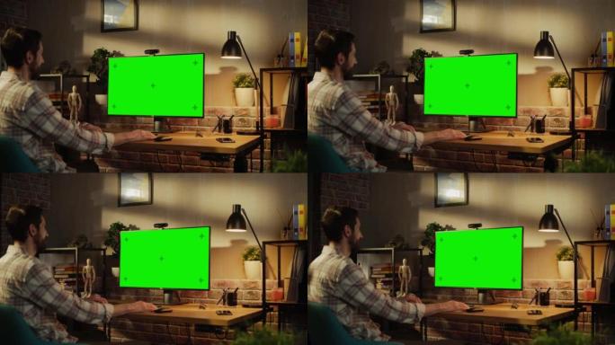 项目经理在家远程工作，在带有带有绿屏模型的显示器的台式计算机上进行视频通话。男人坐在客厅里，与商业伙