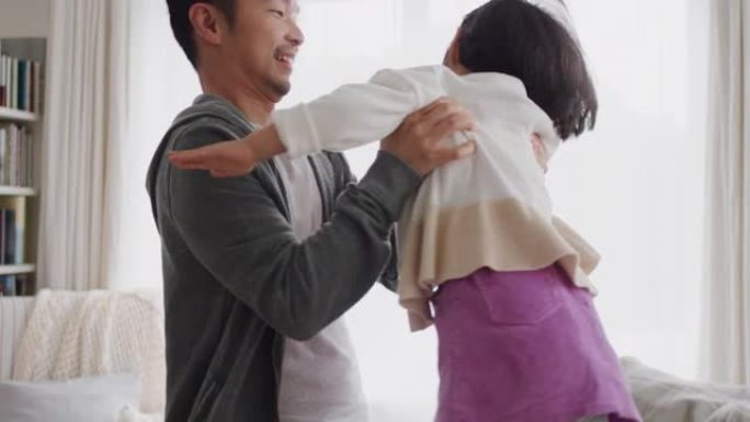 亚洲爸爸抱着快乐的小女孩在家和爸爸玩得开心4k