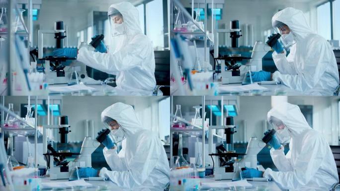 美丽的女医学家穿着工作服和口罩在显微镜下看着培养皿。具有现代设备的疫苗，药物研发创新实验室