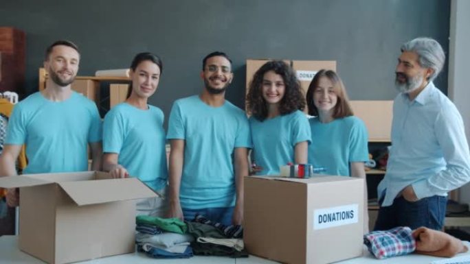 慈善公司员工站在办公室微笑着的捐款箱的慢动作肖像