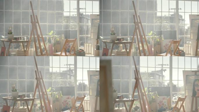一个空的艺术工作室，房间里有一个画架和椅子。在温暖的日子里，城市的画家公寓里阳光照耀着家具，帆布，刷