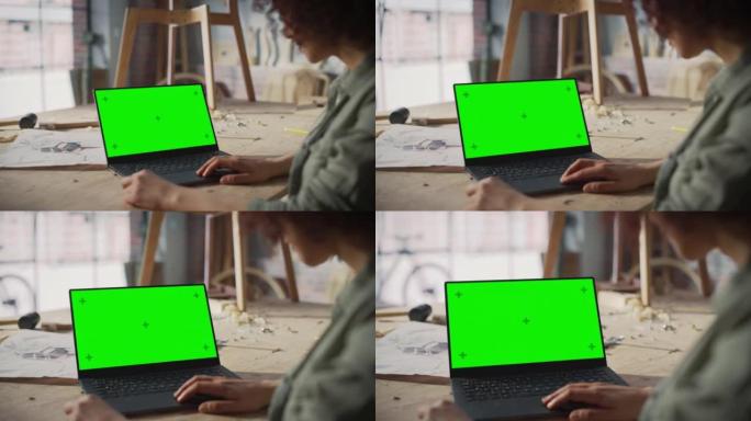 在带有绿屏模拟显示的笔记本电脑上工作的家具设计师的肩膀上。创意女性为木工项目准备设计。