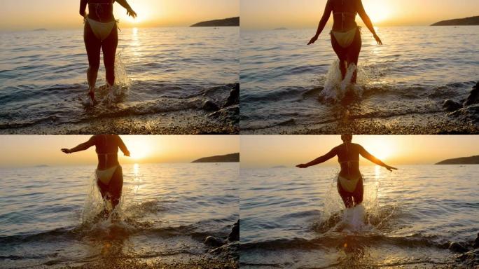 穿着比基尼的超级SLO MO女人在日落时跑进大海