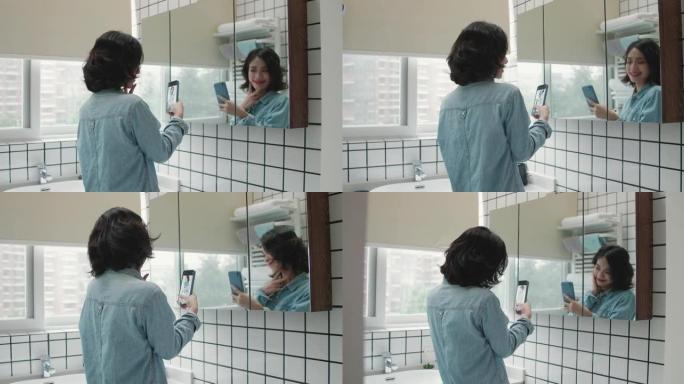 短卷发的年轻女孩在卧室镜子里开心地为手机自拍摆姿势