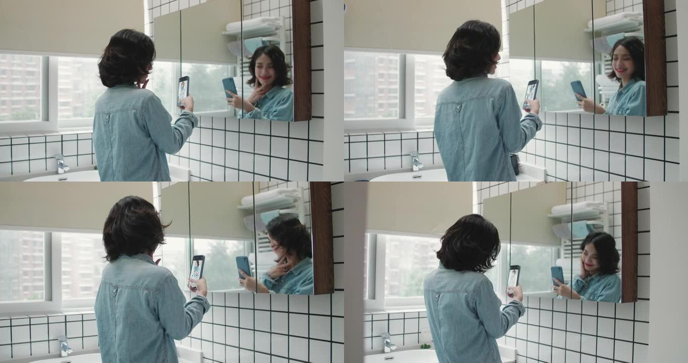 短卷发的年轻女孩在卧室镜子里开心地为手机自拍摆姿势