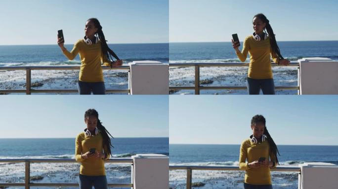 非裔美国妇女使用智能手机在海边的长廊上自拍