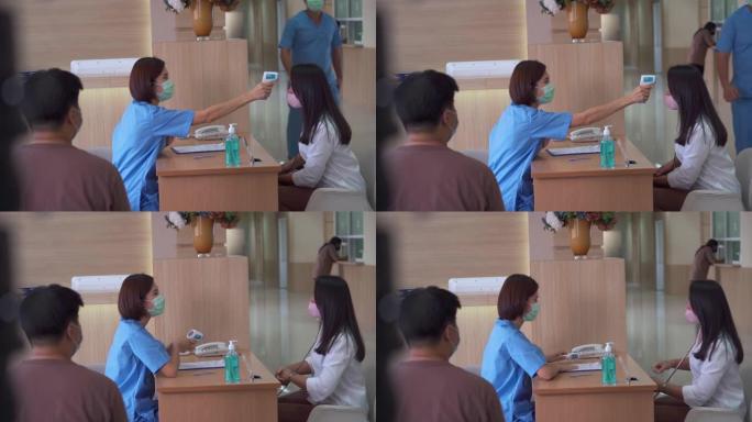 护士在医院接待处为患者做体温检查