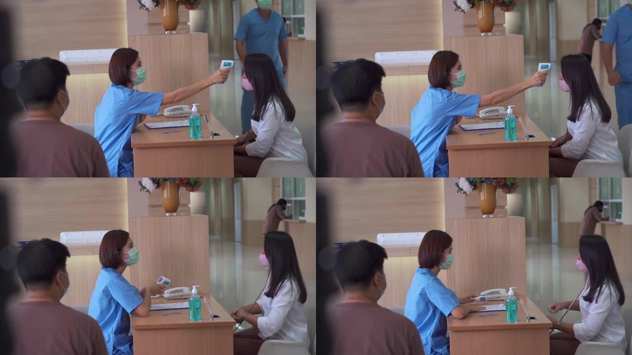 护士在医院接待处为患者做体温检查