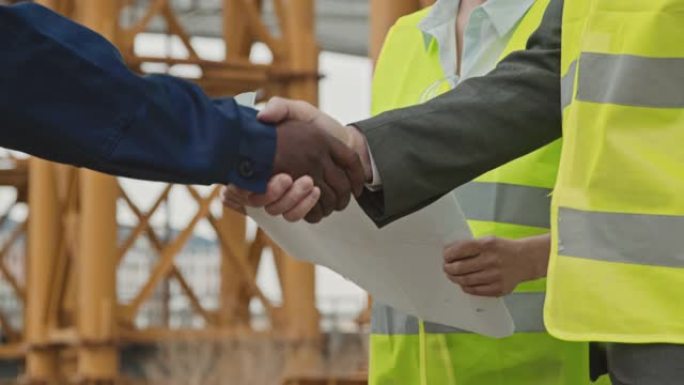 面目全非的建筑工地工人握手