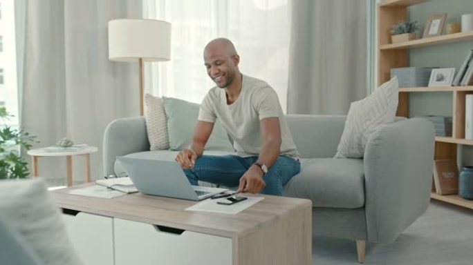 4k视频片段，一名男子坐在家里在笔记本电脑上工作
