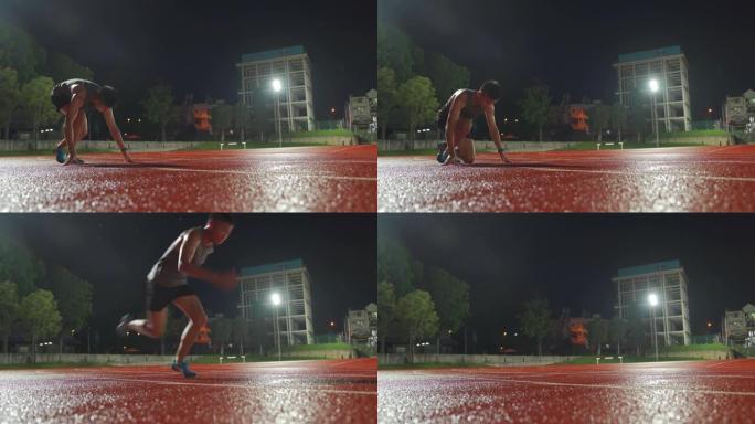 亚洲中国男运动员排队准备起跑线在男子田径雨天深夜在体育场跑步