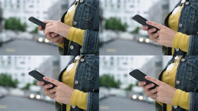 4k视频片段，一名无法辨认的妇女站在城市外面时使用手机