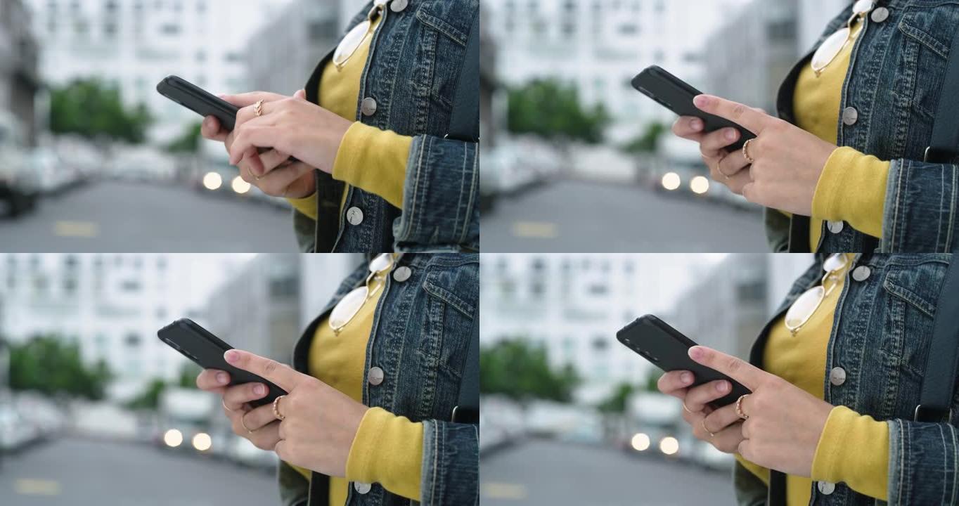 4k视频片段，一名无法辨认的妇女站在城市外面时使用手机